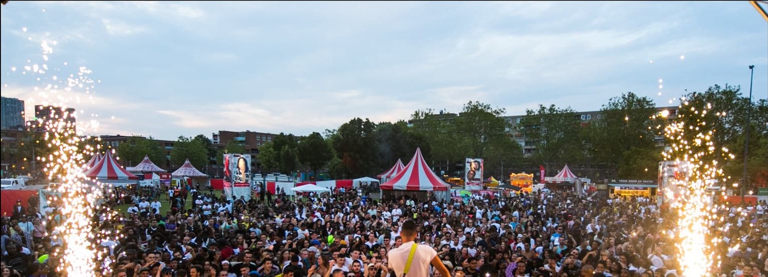 Publiek dicht op elkaar voor het podium op een eerdere GetLoose editie, met vonkenfonteinen aan weerszijden van het podium